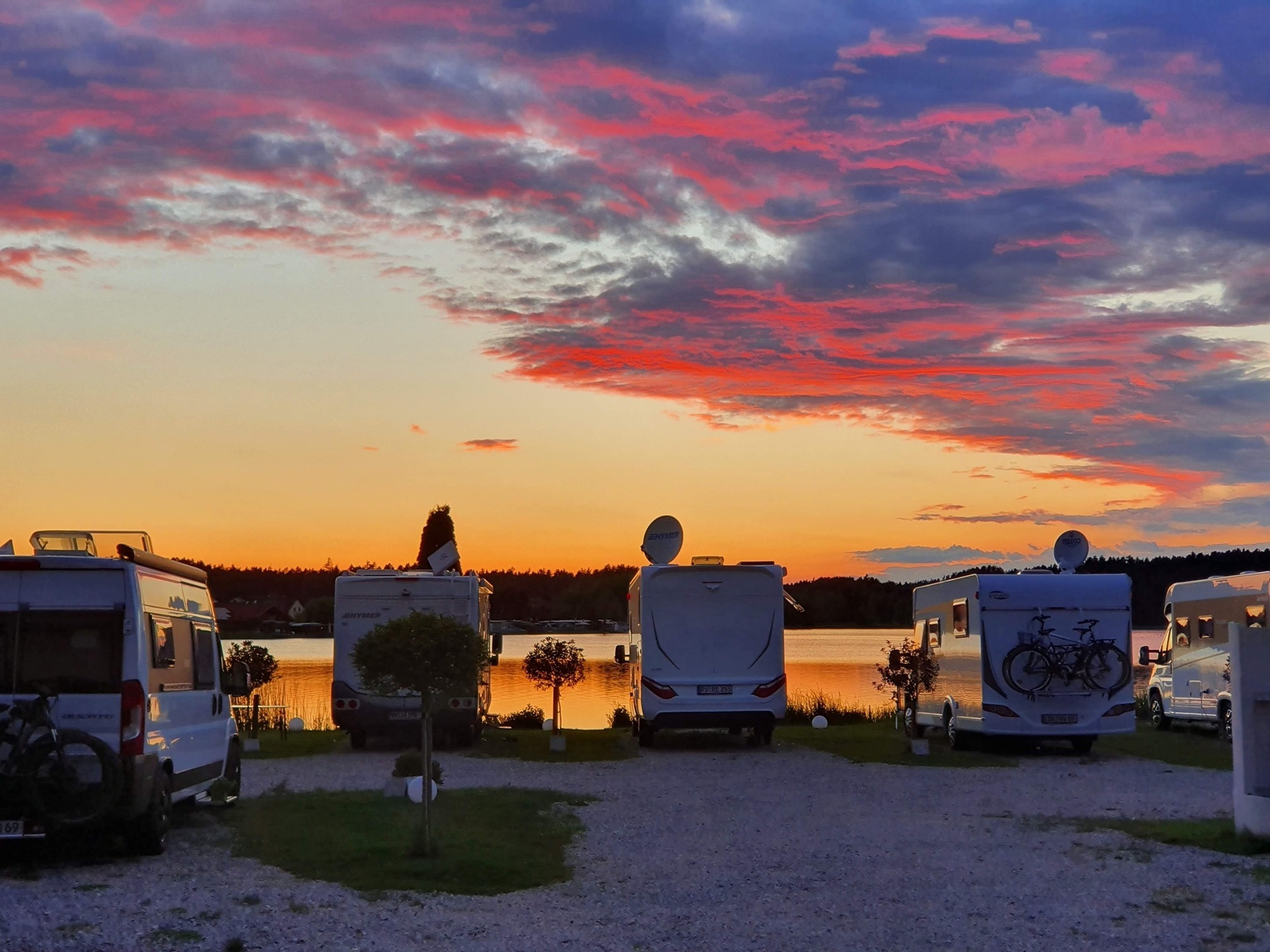 Camper an der Uferpromenade bei Sonnenuntergang - Camping am See Bayern