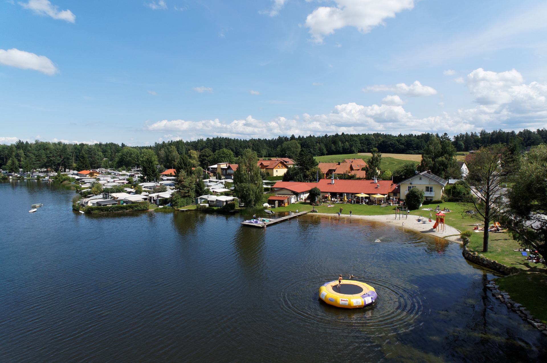 Luftaufnahme Campingpark mit Wassertrampolin - Neubäuer See